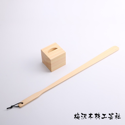 加長檜木鞋拔，附一個同材質的方形鞋拔座，鞋拔末端有黑色掛繩。