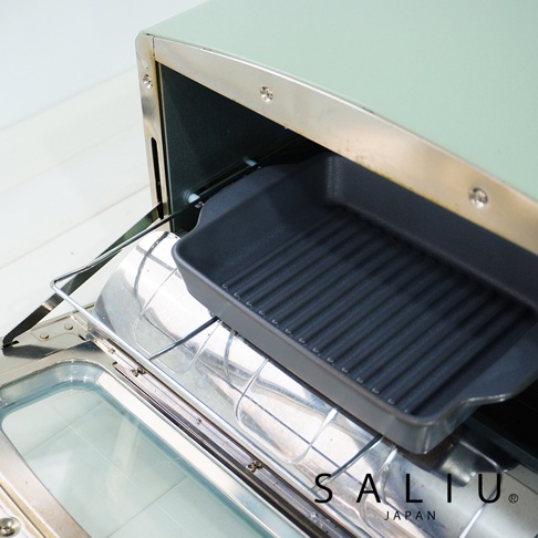 一個深灰色的波浪紋長方形烤盤，置於淺綠色烤箱的烤架上。