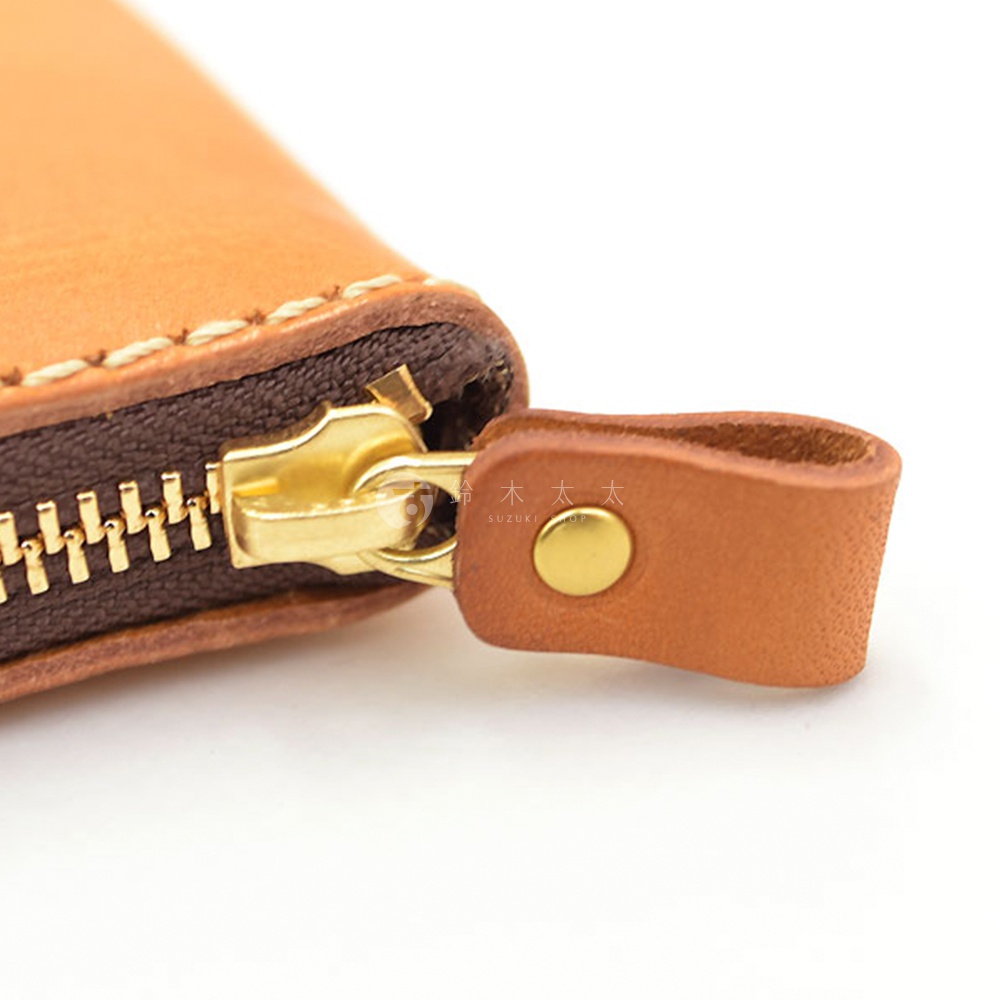 職人手作皮革高機能收納錢包 KK-59，特寫金色拉鍊及淺棕色皮革拉環，皮革表面有細緻縫線，材質為真皮。