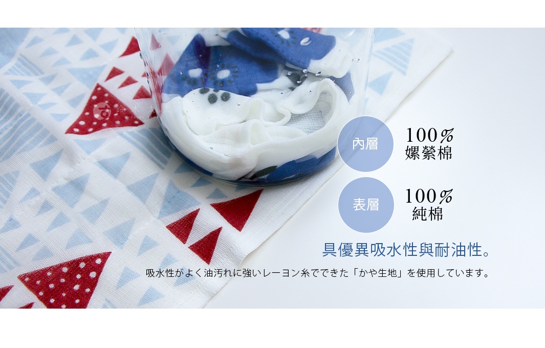 白色七層紗拭巾，印有紅色三角形與淺藍色幾何圖案。一疊白色與藍色花紋的拭巾置於透明玻璃杯中，旁邊標示內層為100%嫘縈棉，表層為100%純棉，具優異吸水性與耐油性。
