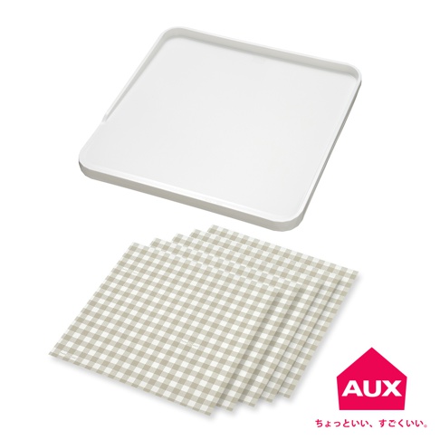 白色方形防溢大砧板，邊緣有淺淺的凹槽，下方疊放著數張米白色格紋的砧板防汙紙。