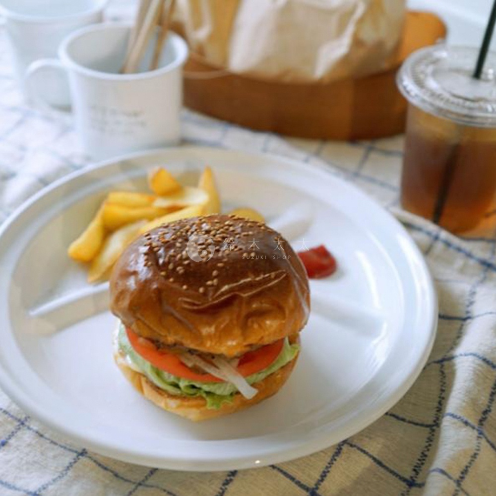 一個有漢堡、薯條和番茄醬的白色琺瑯分隔餐盤。