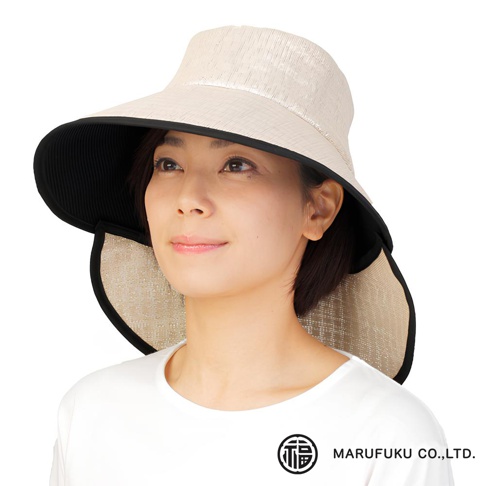 這位女士佩戴著一頂米白色的寬緣遮陽帽，帽緣內側為黑色，帽檐部分採用編織紋理的材質，並有可延伸的遮頸設計。