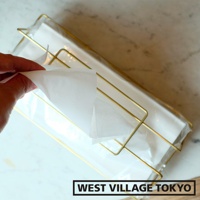 黃銅金屬材質的收納面紙盒，盒身為簡潔的線條設計，內有白色面紙。