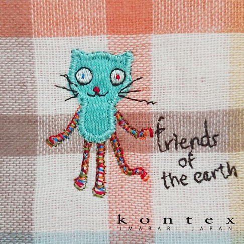 模式B： 一條印有藍色刺繡貓咪和「friends of the earth」字樣的馬德拉斯格紋毛巾，下方有 kontes imabari japan 商標。
