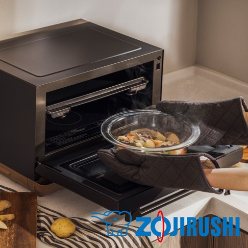 STAN美型烘烤微波爐 ES-SAF26，黑色機身，內部有烤架。一雙深棕色隔熱手套正取出一個裝有燉煮食物的透明玻璃碗，碗內有肉塊、馬鈴薯、紅蘿蔔和蔥段，冒著熱氣。