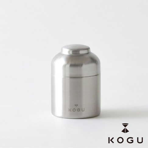 日製18-8不鏽鋼儲豆罐，罐身為銀色圓柱形，頂部有圓形蓋子，正面印有KOGU品牌標誌。