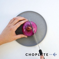 手持刀具正在切割灰色圓形砧板盤上的紫洋蔥，砧板盤上方有「CHOPLATE from KsJ」文字標誌。