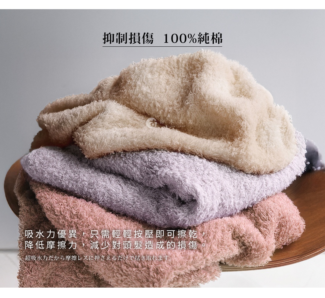 這是一疊不同顏色的毛巾，最上方的是米白色，中間是淺紫色，最下方是粉紅色。毛巾材質蓬鬆柔軟，有著獨特的紋理。圖片上方有中文標語「抑制損傷 100%純棉」，下方則有更多中文說明，介紹毛巾的吸水和護膚特性，以及日文的補充說明。