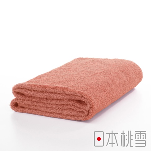 一張珊瑚粉色的精梳棉飯店浴巾，對折後平放在白色背景上，浴巾質地柔軟，有細緻的絨毛感。