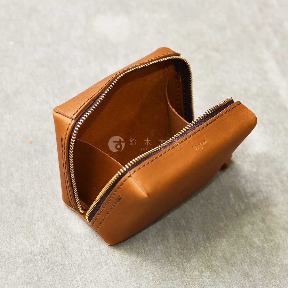 一個打開的棕色皮革Organ箱型收納包，內有兩個隔層，拉鍊是黃銅色。