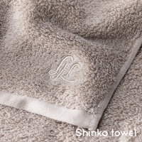 Landwell Hotel 泉州精繡長纖匹馬棉毛巾，採用柔軟的匹馬棉材質，呈現細緻的織紋與精緻的「L」字樣刺繡，毛巾為暖沙色調，質地蓬鬆。