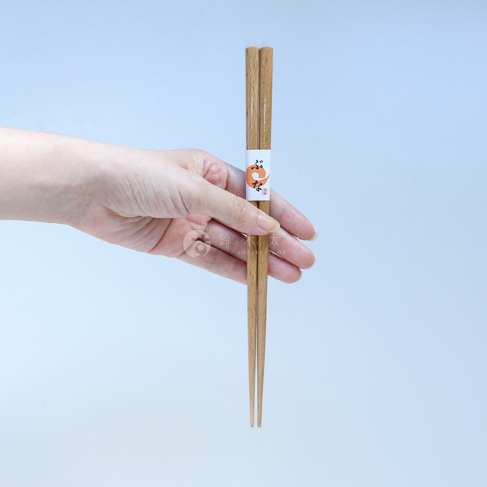 一隻手拿著一組天然木色筷子，筷子中間有一張印有橘色狐狸圖案的白色紙帶。