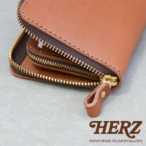 職人手作皮革Organ拉鍊長夾，展現溫潤的棕色皮革與精緻的拉鍊細節，內部結構清晰可見，搭配黃銅拉鍊頭和同色系皮革拉環，質感獨特。