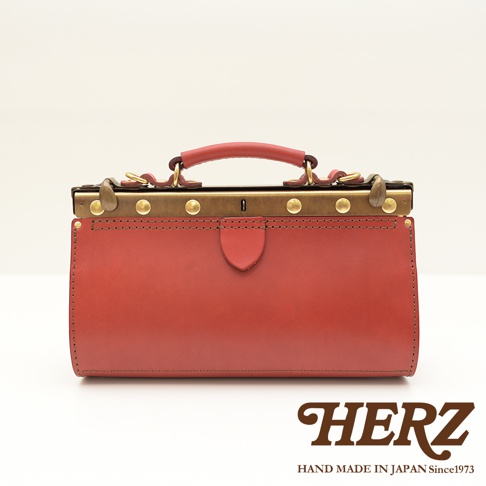 職人手作皮革復古口金兩用手提包，紅色皮革，搭配黃銅色金屬口金、鎖扣及提把，設計簡約，質感細緻。