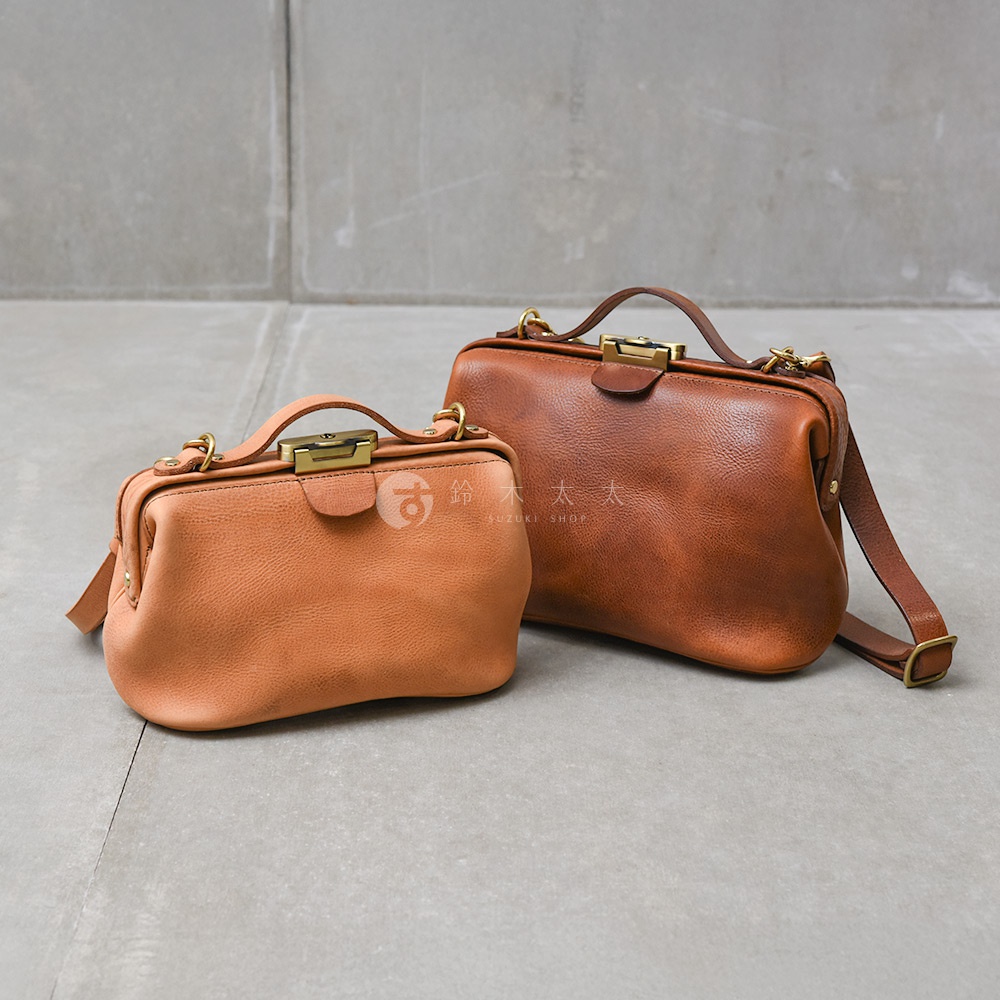 日本HERZ職人手作皮革Organ鎖孔式大開口肩背包，有大小兩個尺寸，皆為棕色皮革，精緻的金屬鎖孔和肩帶細節，呈現職人精湛工藝。