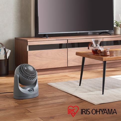 PCF-MKM15 空氣循環扇，灰色塑膠材質，圓形扇葉網罩，可調整角度的底座，放置於木質地板上。