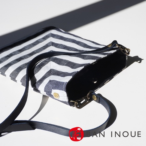 BAN INOUE 斑馬條紋麻布斜背包，附有可拆卸皮革肩帶和金屬鉤扣。