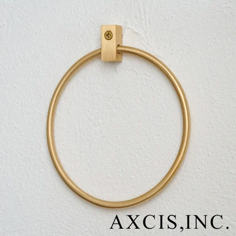 輕奢黃銅圓形毛巾環，固定在白色紋理牆面上，黃銅材質呈現啞光金色，簡約設計。