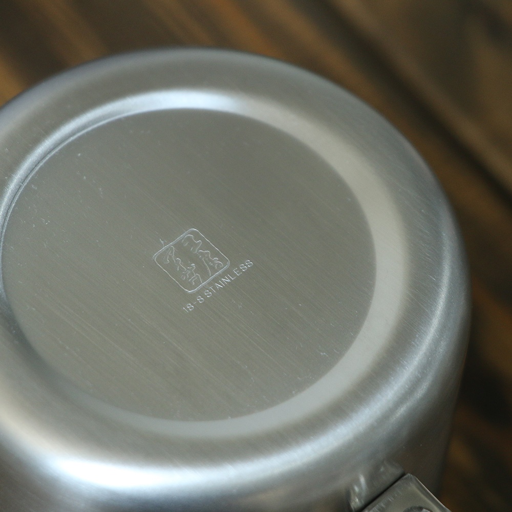 不鏽鋼霧面直筒茶壺底部，標示著「18-8 STAINLESS」字樣及品牌圖案。