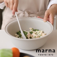 marna TOKYO 1872 標誌下方，一個米色洗濾盆中裝有雞胸肉、小黃瓜丁和馬鈴薯丁，一隻手正用白色刮刀攪拌。