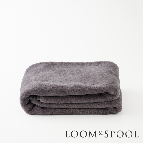 單人厚實保暖墊，深灰色美麗諾羊毛材質，質地柔軟，整齊對折置於純白背景上。