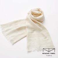 淺米色今治匹馬棉圍巾，質地輕柔，織紋細膩，兩端帶有流蘇，展現出經典優雅的風格。