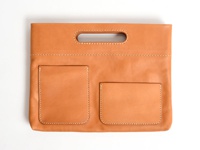 職人手作咖啡色皮革橫式收納袋中袋，具有一個長方形提把，正面有兩個方形的置物口袋，縫線清晰。