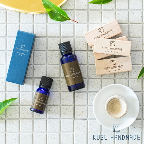 深藍色禮盒、兩個深藍色精油瓶，以及一疊淺木色樟楠木條。