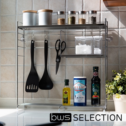 銀色不鏽鋼三層收納架，展示有白色儲物罐、玻璃調味罐、黑色調理夾、剪刀、透明儲物盒、橄欖油、海鹽及義大利黑醋。
