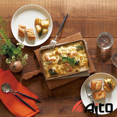 美濃燒釉彩萬用長方烤盤，內盛有焗烤義大利麵，搭配烤麵包與馬鈴薯塊，擺設於木製桌面。