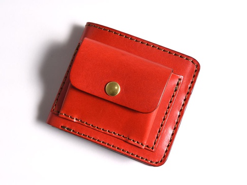 職人手作雙折短夾，採用紅色皮革，外附一個帶有黃銅釦的零錢袋，邊緣縫線清晰。
