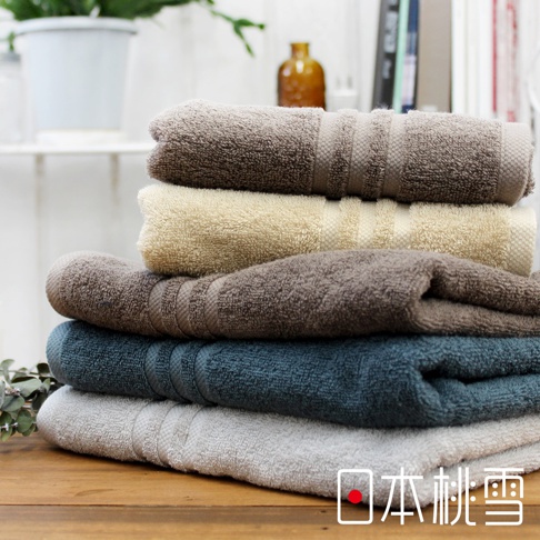 一疊今治飯店浴巾，顏色包含深棕、米黃、淺棕、藍綠及淺灰。浴巾材質柔軟，表面有條紋織紋。