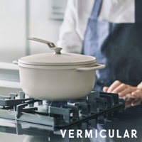 淺灰色琺瑯鑄鐵鍋 OP2 22cm，帶有同色鍋蓋及銀色提把，置於黑色瓦斯爐上加熱。