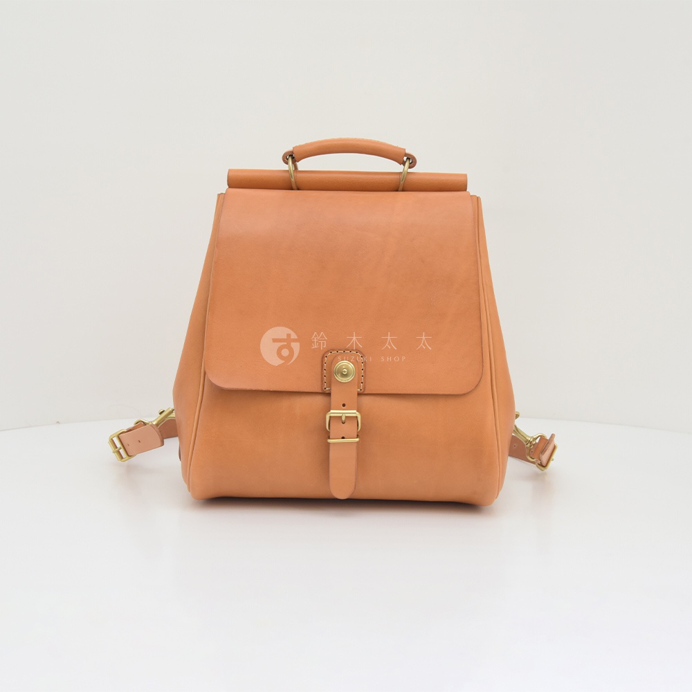 職人手作皮革屋瓦風後背包 R-15，採用天然棕色皮革，設計簡約，附有金屬扣環與可調式肩帶，風格復古。