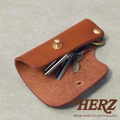 職人手作皮革鑰匙套，採用經典棕色皮革，設有黃銅壓扣及掛環，可收納多把鑰匙，展現簡約實用的設計。