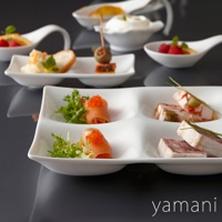 白色陶瓷四格小菜盤，盛裝著煙燻鮭魚佐魚子醬、蔬菜沙拉、肉凍等精緻小點。