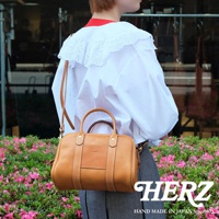 HERZ 職人手作皮革兩用迷你波士頓包，以柔軟親膚的Stare牛皮革製作，可手提或肩背，附有可拆式背帶，包身圓潤，搭配厚實提把，展現簡約俐落的設計風格。