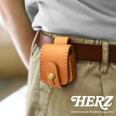 淺棕色皮革製作的腰間小物收納包，透過手工縫線縫合，設有原子釦開合，可掛於皮帶上。