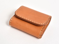 棕色皮革雙折收納零錢包，表面光滑，以米白色縫線手工縫製，呈現簡約設計。