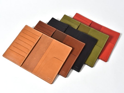 職人手作皮革多用途收納長夾，展示多種顏色，包括原色、咖啡色、黑色、橄欖綠和紅色。長夾為皮革材質，內有卡槽和收納空間，縫線整齊。