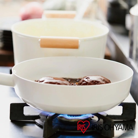 露歐頓LUO-SE10 IH不沾鍋具組，白色鍋身搭配木質提把，前方的平底鍋正在瓦斯爐上烹調兩塊漢堡排。