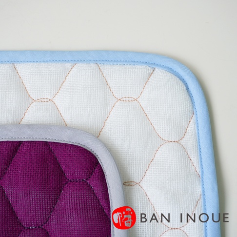 兩塊疊放的吸水墊，一塊為紫色，另一塊為白色，均為棉織材質，菱格紋縫線，搭配淺藍色和灰色滾邊。