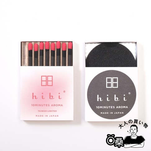 香氛火柴組合台灣限定版，左側為粉紅色漸層紙盒裝，內有八支黑色木質火柴，頂端為粉紅色火藥頭；右側為白色紙盒，內有黑色圓形香氛片。