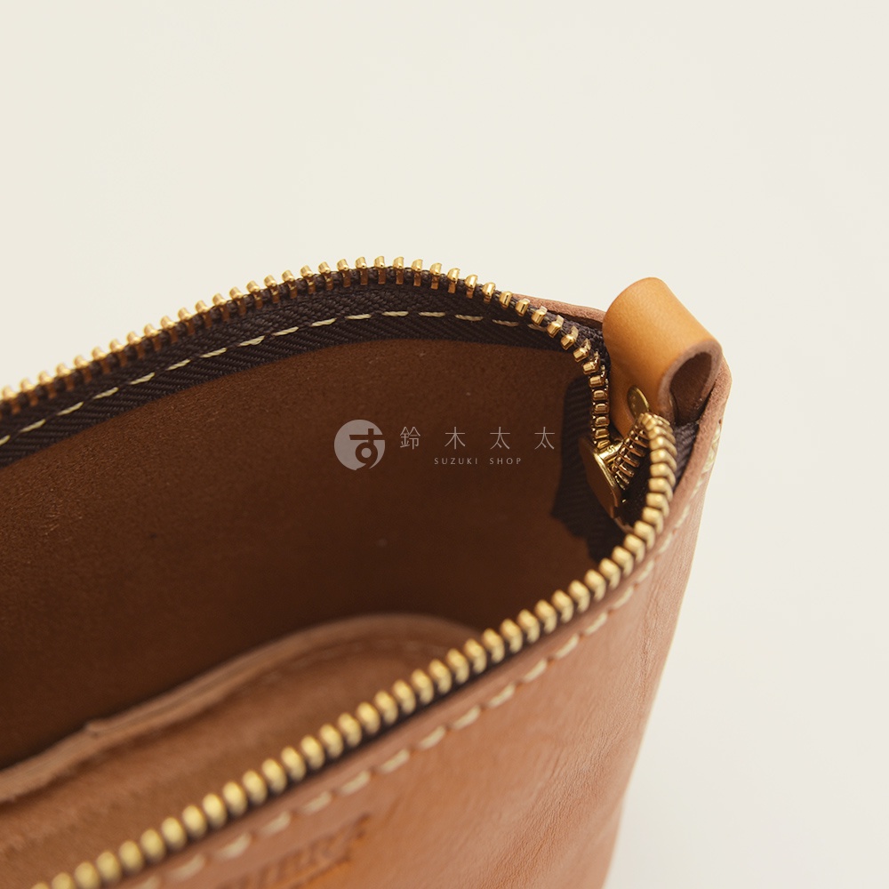 職人手作皮革三角收納包 KF-1，淺棕色皮革，金色拉鍊，內裡為深棕色絨布，車縫線為米白色。