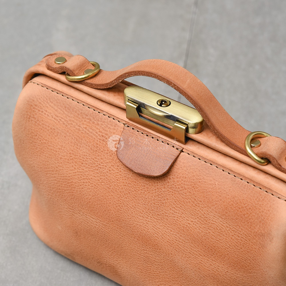 日本HERZ職人手作皮革Organ鎖孔式大開口肩背包，展示包包的頂部細節，包括皮革提把、復古金色鎖扣和金屬圓環。