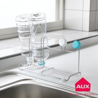 不鏽鋼瓶壺瀝水架，架上放置兩個已清空的透明塑膠瓶，瓶口朝下。瀝水架為金屬製，設有兩層支架，上面可放置瓶身，下方則有集水盤。架子旁有兩個不同顏色的瓶蓋，分別為白色和藍色。