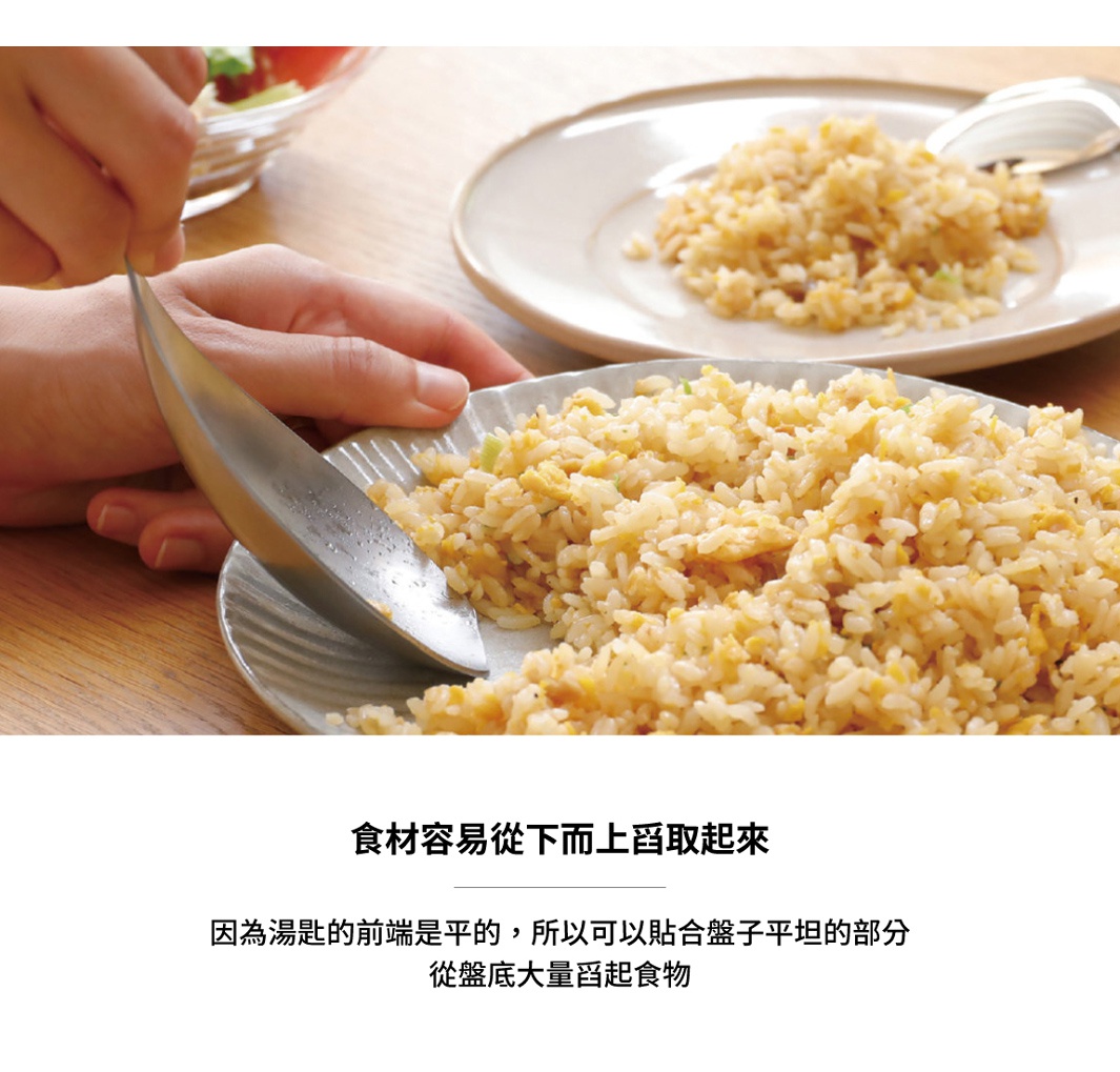 日式炒飯盛裝情景，一名女子正用不鏽鋼瀝湯勺舀取炒飯，炒飯堆疊在盤中，背景有另一盤炒飯和餐具。