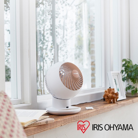 白色IRIS OHYAMA PCF-SC15T空氣循環扇，圓形風扇頭設計，帶有木紋色扇葉，置於木製窗台上，背景為窗外景緻。