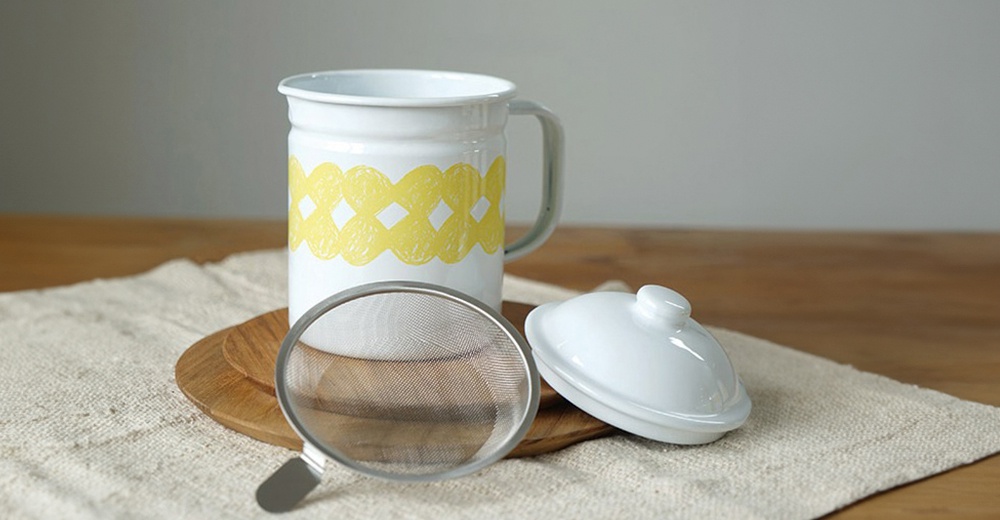 白色琺瑯濾油壺，壺身帶有黃色網狀紋飾，附有金屬濾網及白色琺瑯壺蓋。